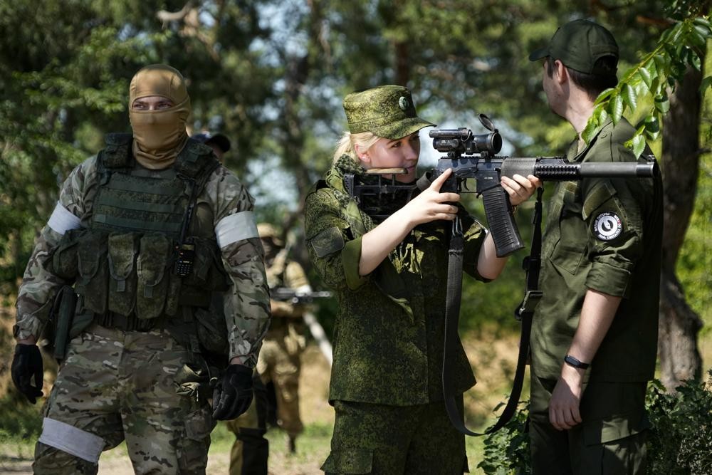 A Russian Army soldier looks through a sniper rifle scope as she and other soldiers guard a group of foreign journalists visiting a captured Ukrainian checkpoint and well-fortified trenches near Schastia town, on the territory which is under the Government of the Luhansk People's Republic control, eastern Ukraine, Saturday, June 11, 2022. This photo was taken during a trip organized by the Russian Ministry of Defense. (AP Photo)